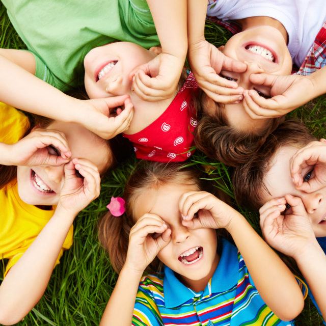 Group of cute children lying on grass